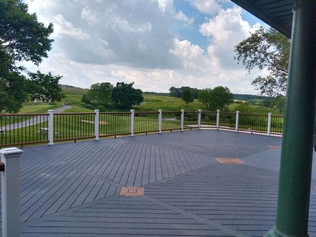 Custom composite deck with diagonal pattern and white post railing overlooking golf course