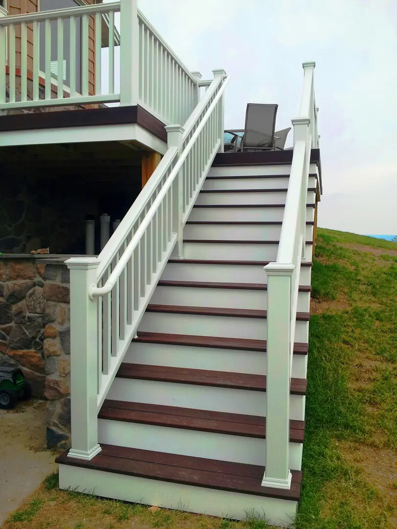 A white and brown staircase with steps leading to the top of the stairs.