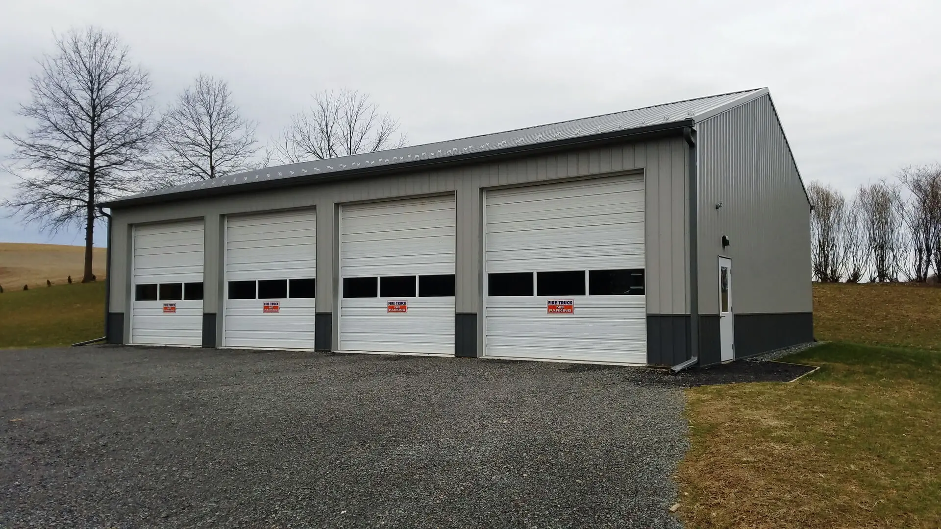 Three garage doors are open on a building.