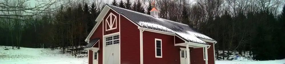 A red barn with a white door and a black roof