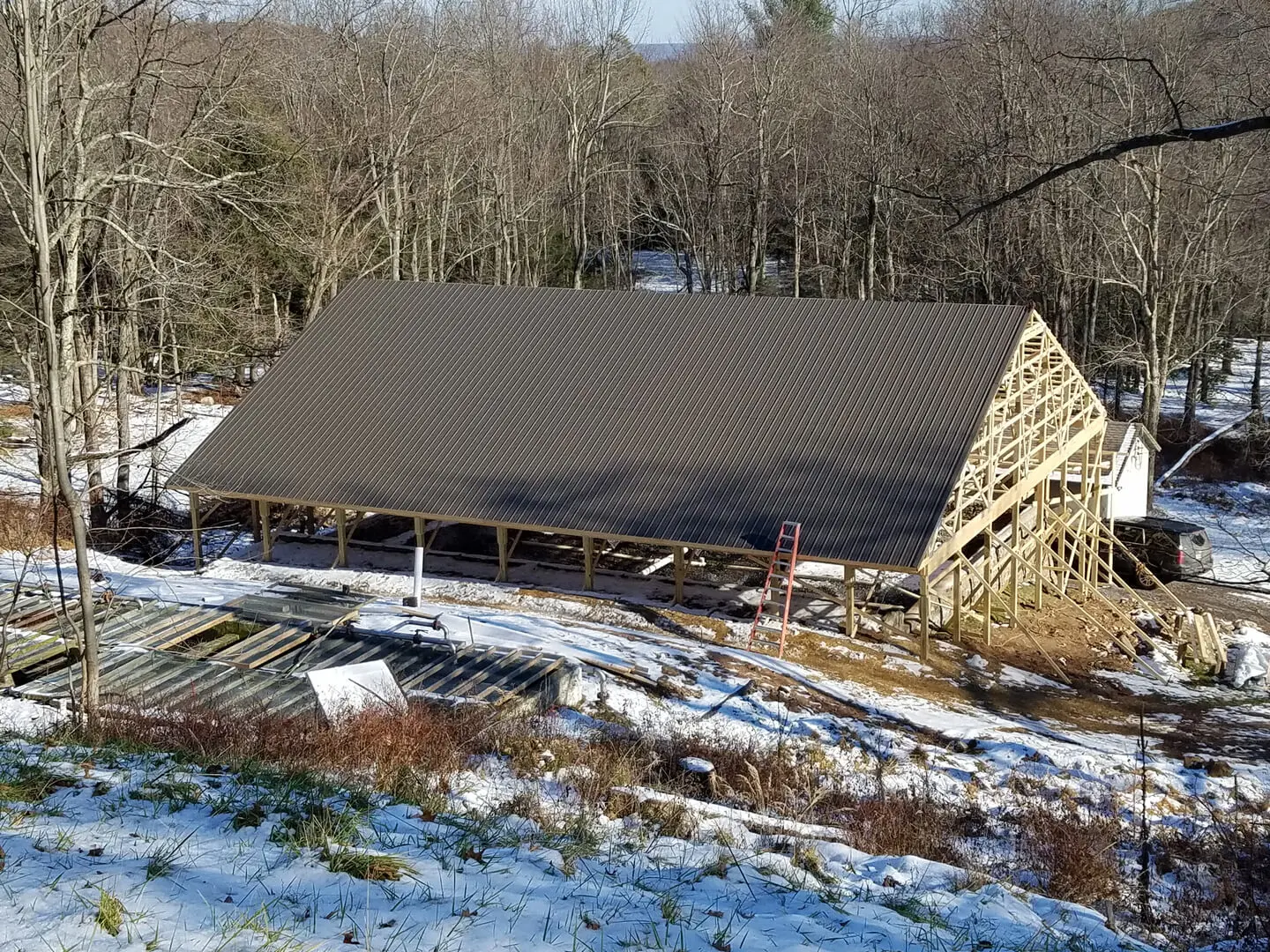 A barn with a roof that is being built.