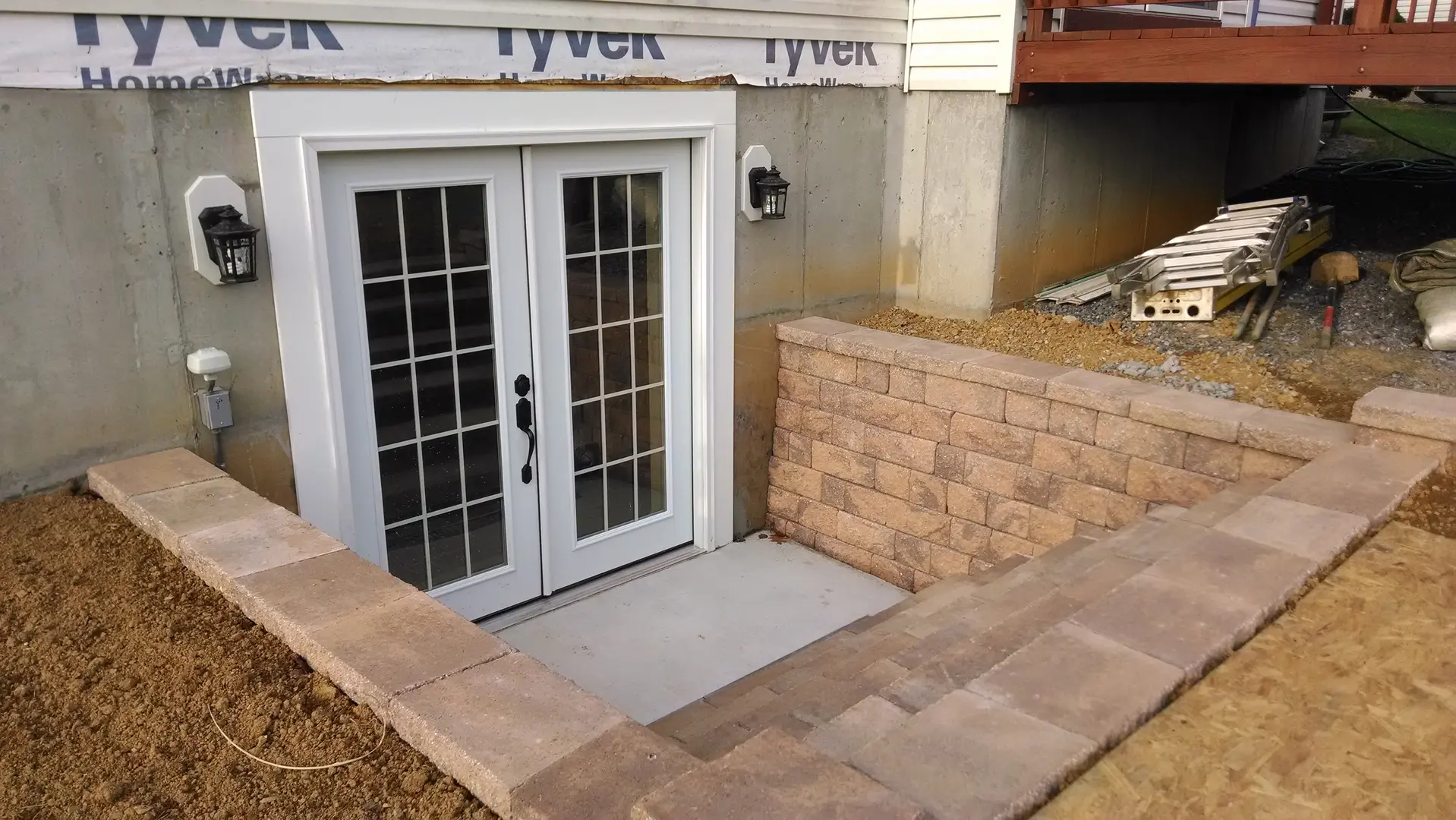 A door way with two doors and brick steps.