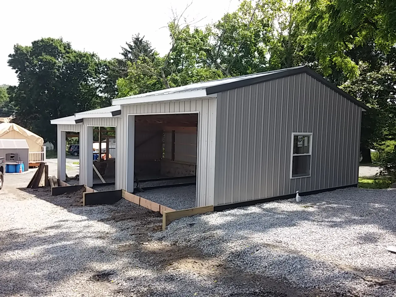 A gray shed with a porch and a door.