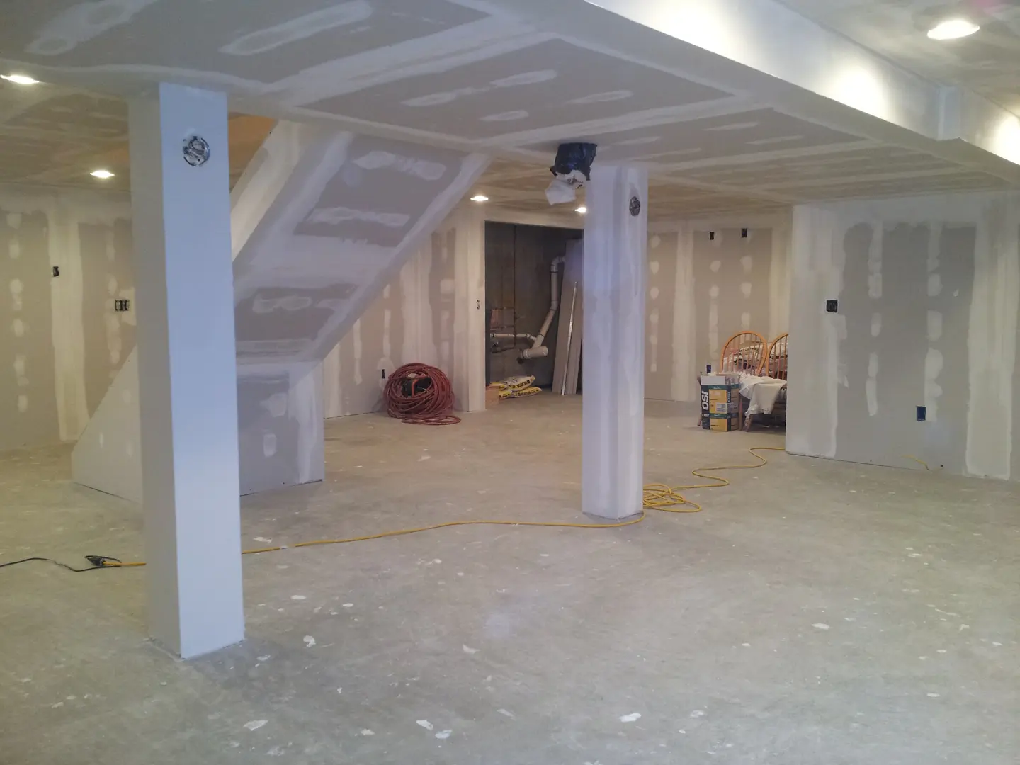 A room with white walls and floors under construction.