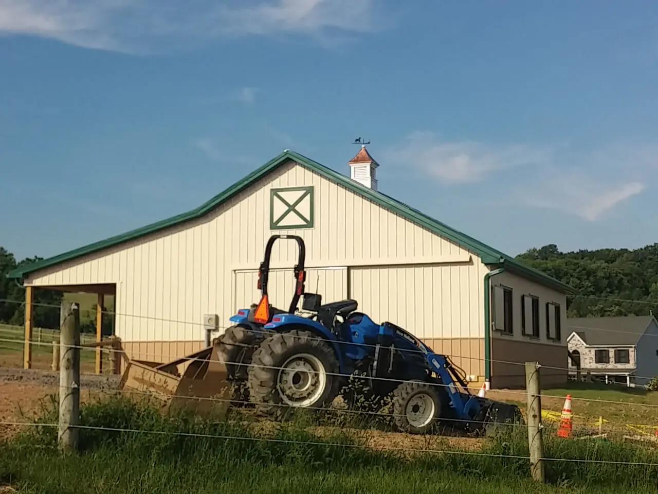 A tractor parked in front of a barn.