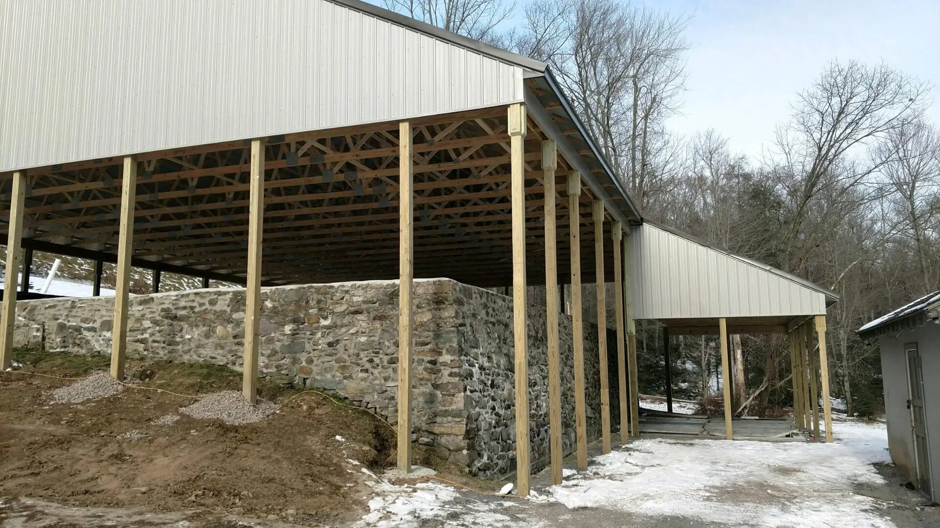 A building with wood posts and stone walls.