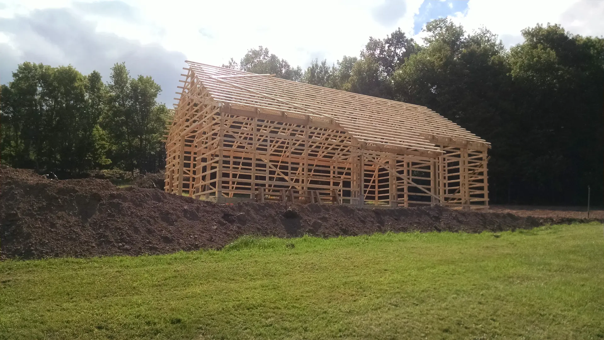 A building that is being built in the grass.