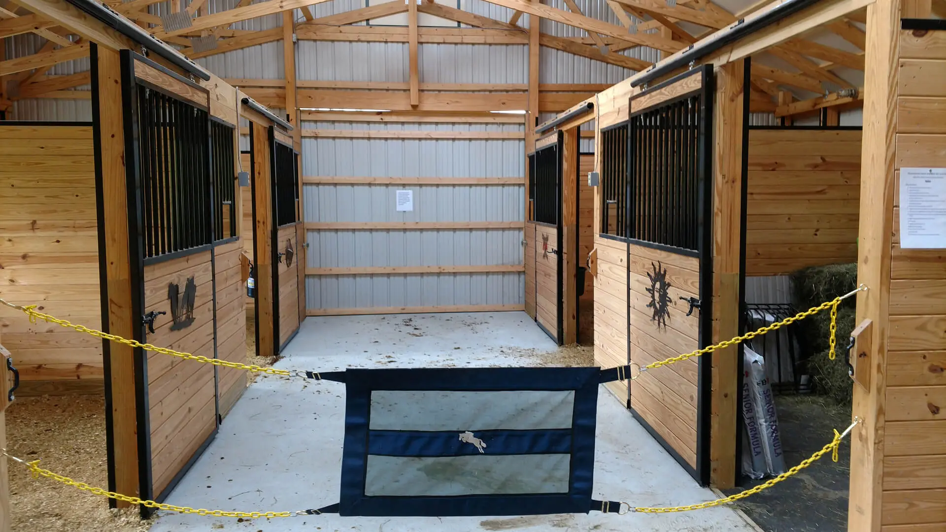 A horse stable with two stalls and one door.