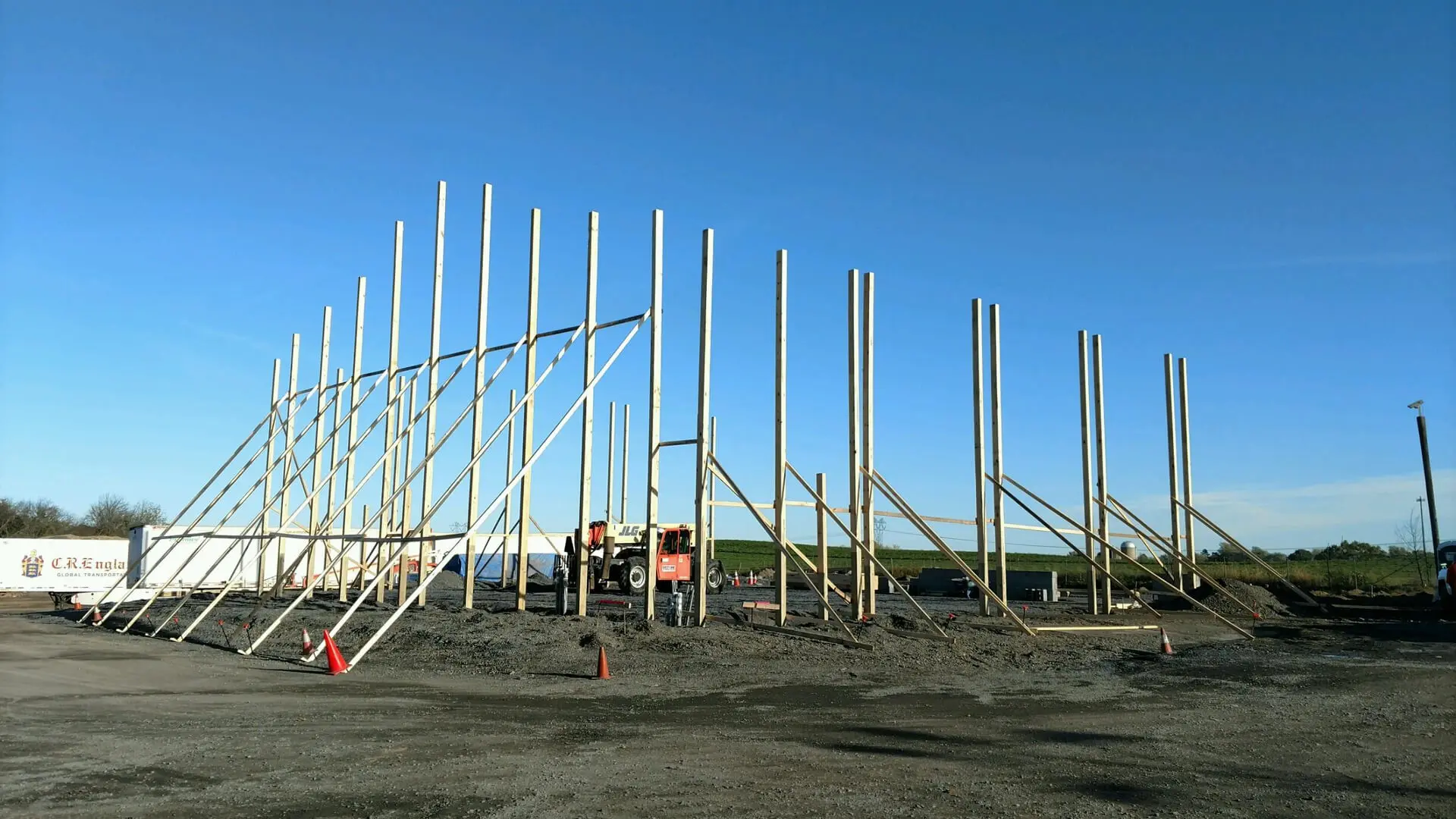 A construction site with many poles in the middle of it.