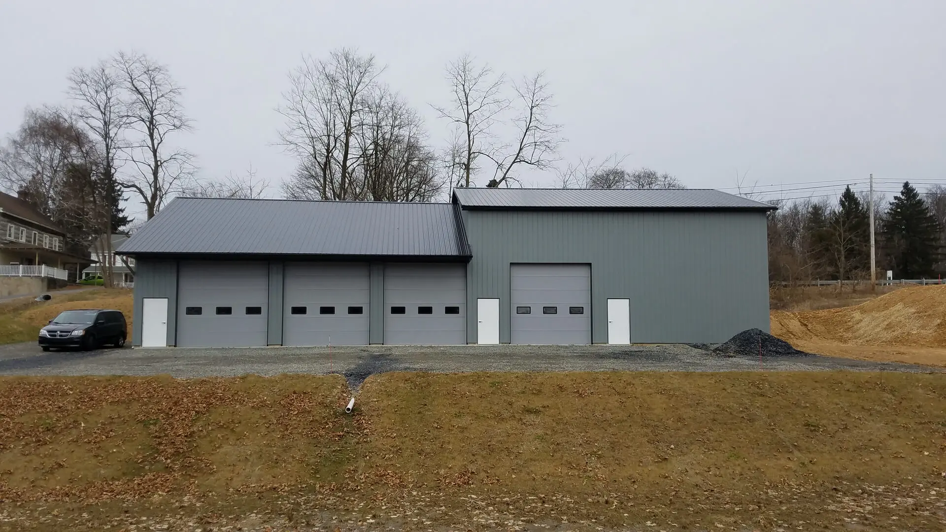 A large building with four garage doors on the side of it.