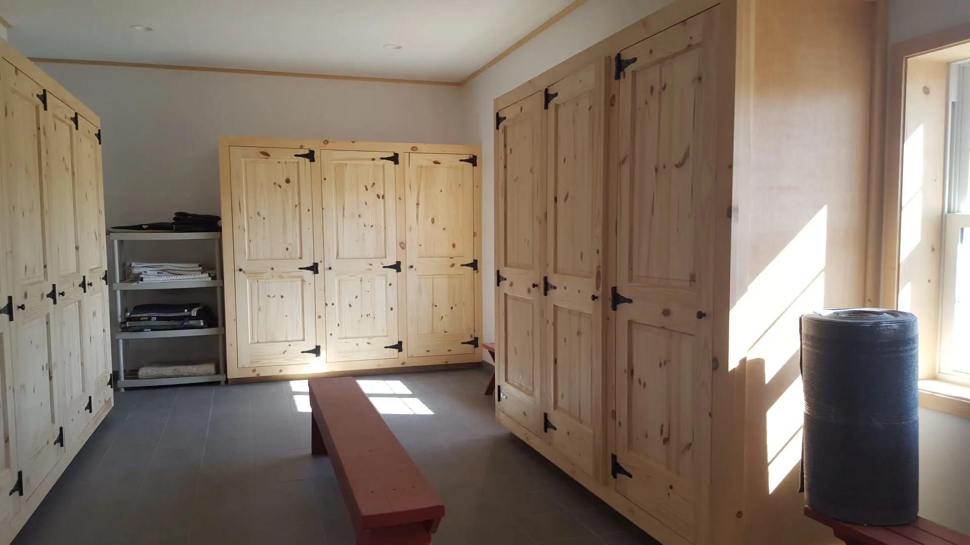 A room with many wooden cabinets and a bench